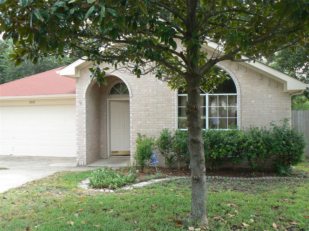 View of exterior entry with brick siding, concrete driveway, and an attached garage