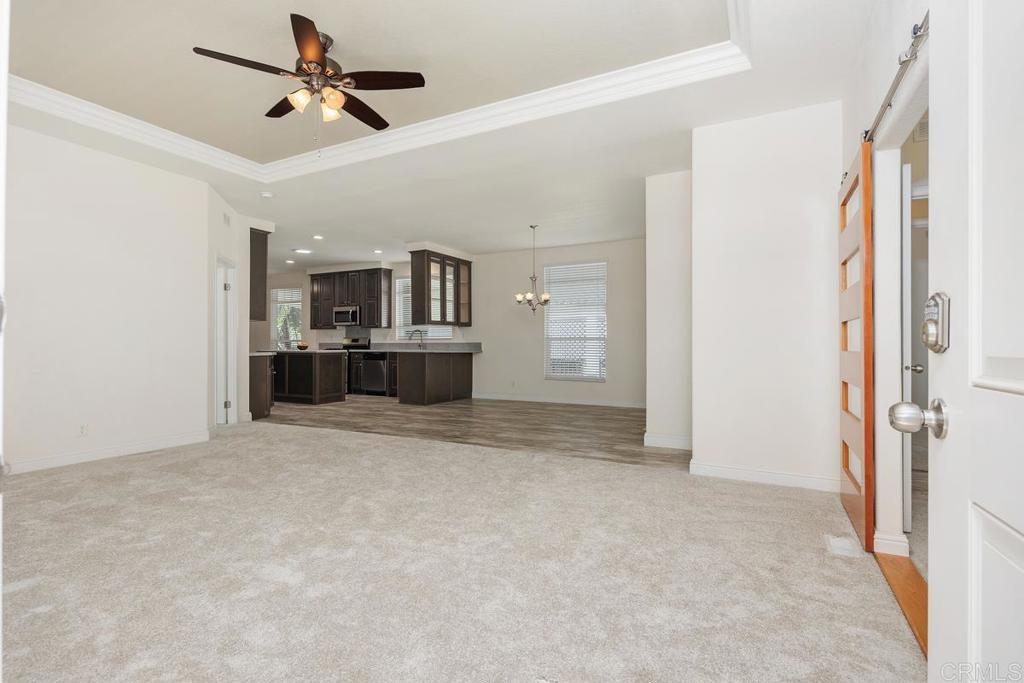 7213 San Luis Street, Unit 171 Carlsbad, CA 92011 - Photo 11 of 44 a view of a livingroom with a kitchen and a ceiling fan