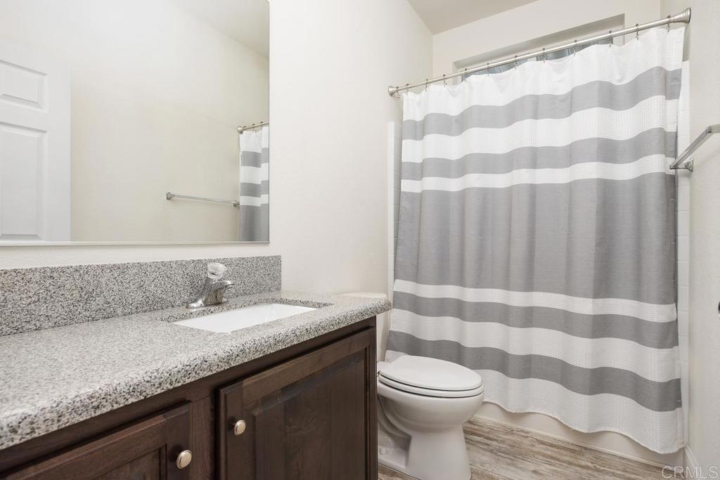 7213 San Luis Street, Unit 171 Carlsbad, CA 92011 - Photo 18 of 44 a bathroom with a granite countertop sink and a toilet