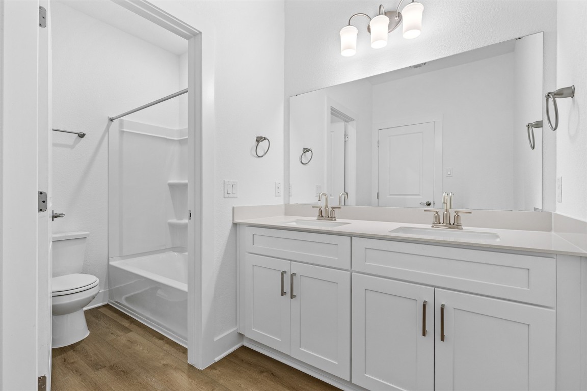 1955 Settlers Glen Drive, Unit 4301 Round Rock, TX 78665 - Photo 11 of 19 a bathroom with a double vanity sink toilet and shower