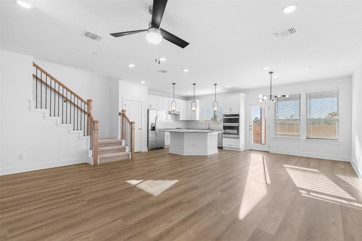 1955 Settlers Glen Drive, Unit 4301 Round Rock, TX 78665 - Photo 3 of 19 a view of a kitchen with wooden floor and windows