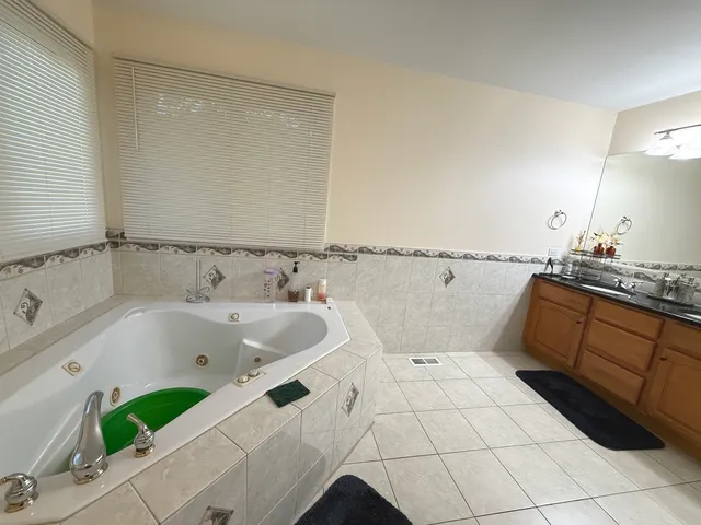a bathroom with a tub sink and mirror