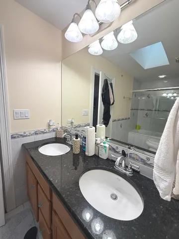 a bathroom with a double vanity sink and a mirror