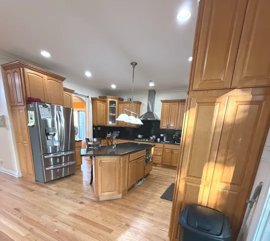 a kitchen with stainless steel appliances granite countertop a refrigerator a stove top oven and sink