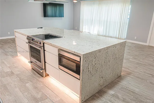 a kitchen with granite countertop a stove and a microwave