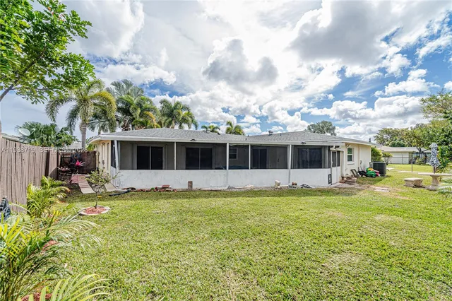 a view of a house with backyard and sitting area