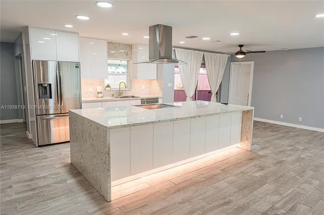 a kitchen with stainless steel appliances granite countertop a refrigerator and a sink