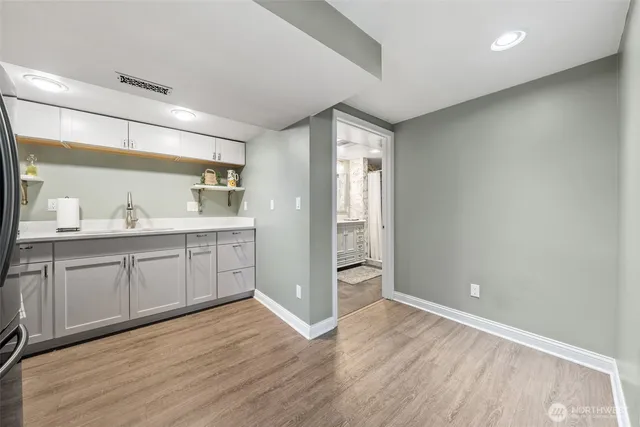 a view of a kitchen with a sink and wooden cabinets