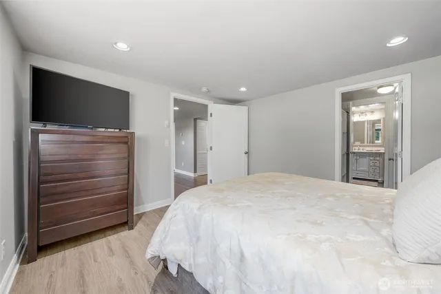 a spacious bedroom with a bed and a flat screen tv