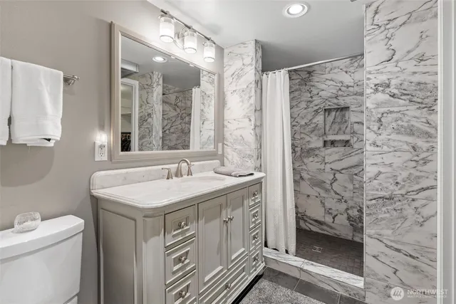 a bathroom with a sink a toilet and a shower