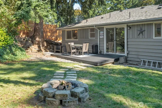 a backyard of a house with yard table and chairs