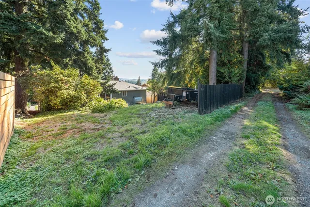 a view of backyard with table and chairs and wooden fence