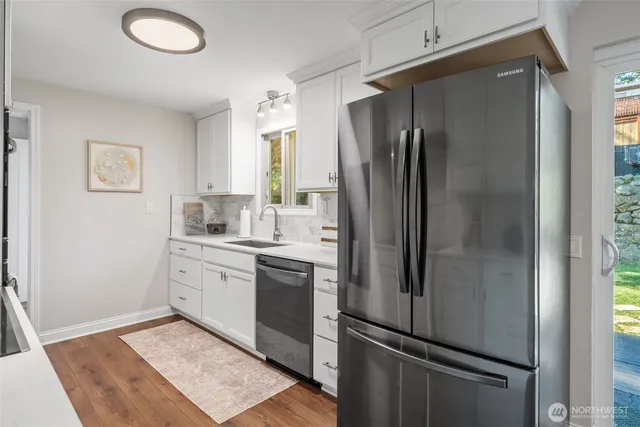 a kitchen with stainless steel appliances granite countertop a refrigerator and a sink