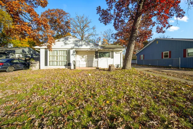 front view of a house with a large tree