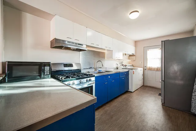 a utility room with cabinets washer and dryer