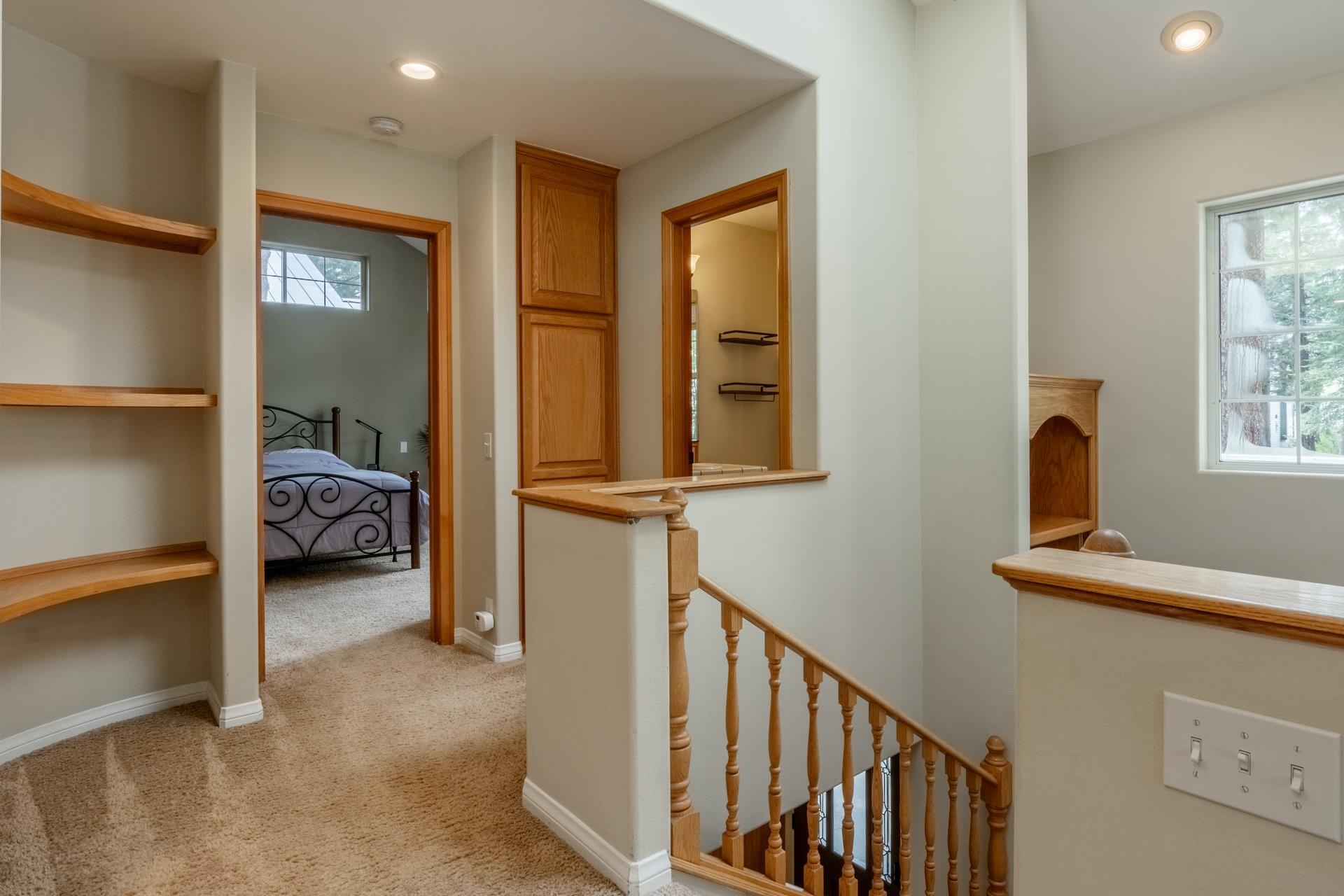 272 Ridge Way Mammoth Lakes, CA 93546 - Photo 29 of 55 Carpeted hallway featuring built-in wooden shelving, a wooden staircase with balusters, and recessed lighting