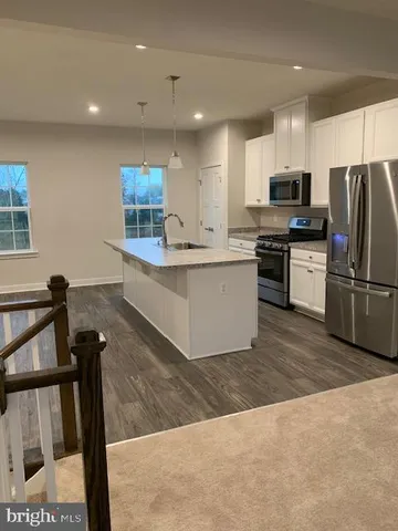 a kitchen with stainless steel appliances granite countertop a refrigerator sink and stove
