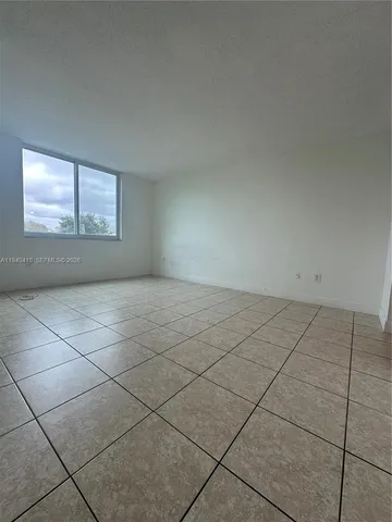 a view of a livingroom with an empty space and a window
