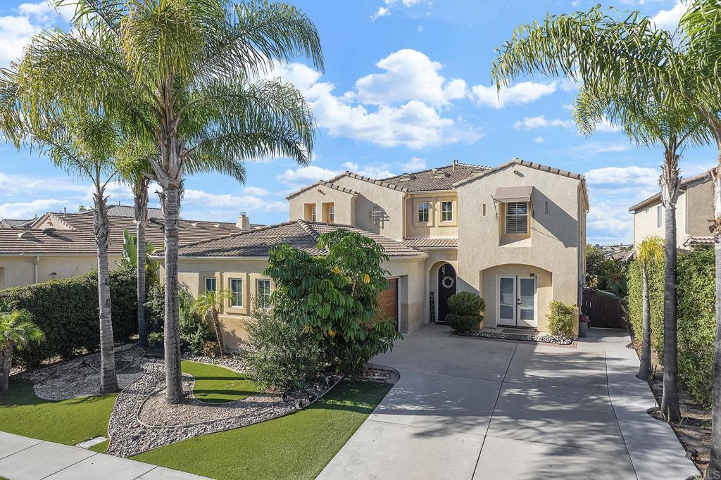 a view of a white house with a yard and palm trees
