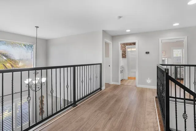 a view of a hallway with wooden floor and staircase