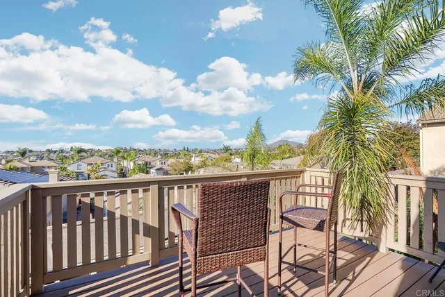 a view of a balcony with wooden floor and iron fence