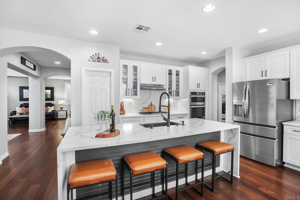 1777 Clover Tree Court Chula Vista, CA 91913 - Photo 8 of 49 a kitchen with stainless steel appliances granite countertop a dining table chairs refrigerator and stove