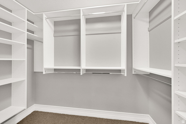 4792 Glasmann Way South Ogden, UT 84403 - Photo 35 of 70 Primary suite walk-in closet featuring white built-in shelving, multiple hanging rods, and carpeting