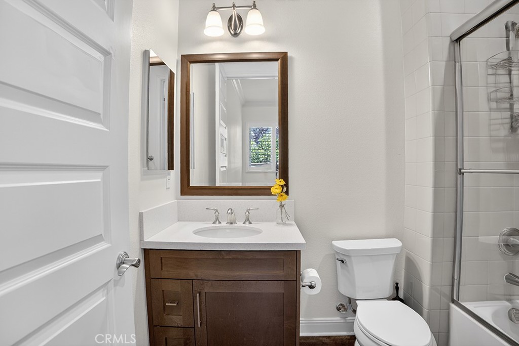19843 Split Oak Road Chatsworth, CA 91311 - Photo 48 of 75 a bathroom with a toilet sink and mirror