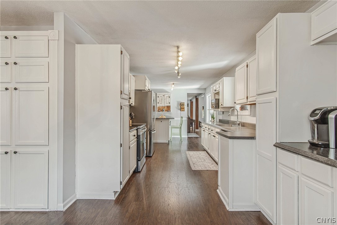 15384 Fuller Road Adams, NY 13606 - Photo 28 of 50 Rich hardwood flooring pairs with classic white cabinetry in this functional galley layout.