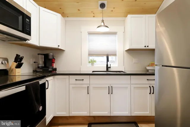 a kitchen with white cabinets and black appliances