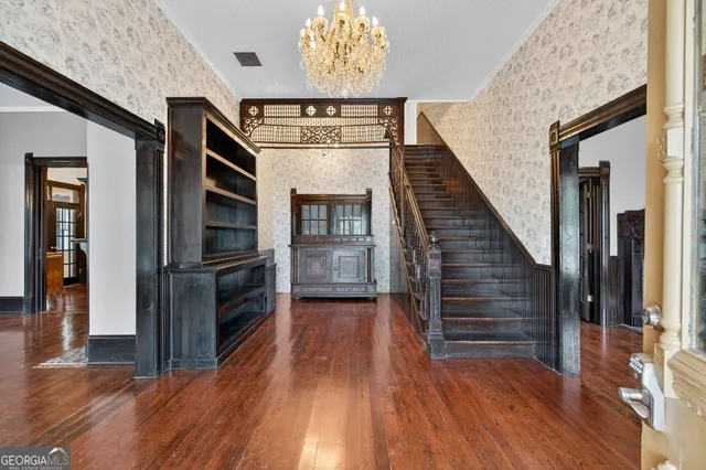 a view of a hallway with wooden floor and staircase