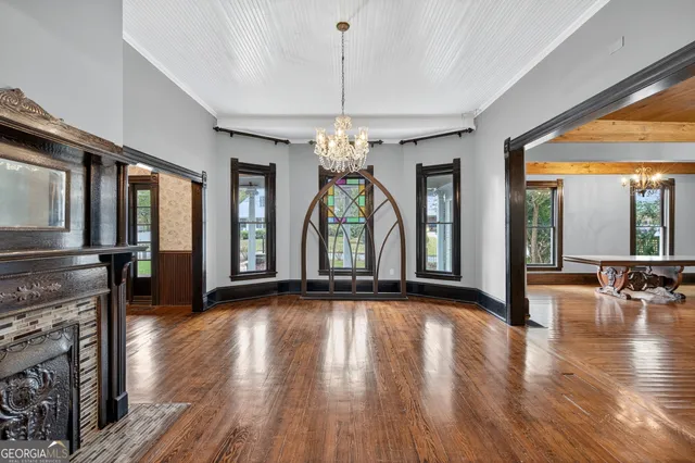 a view of a room with wooden floor fireplace and windows
