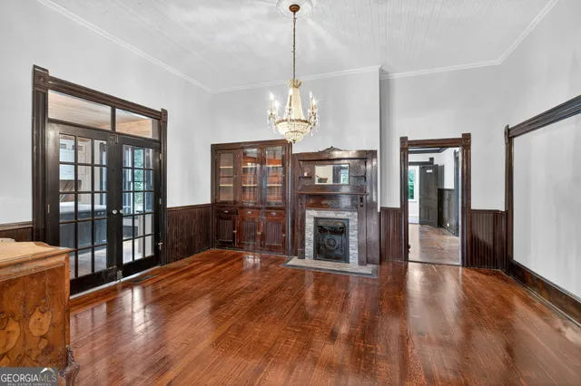 a hallway with wooden floor fireplace and windows