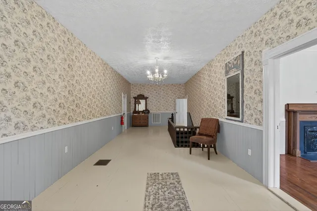a view of a hallway with furniture and chandelier
