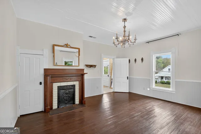 wooden floor fireplace and windows in an empty room