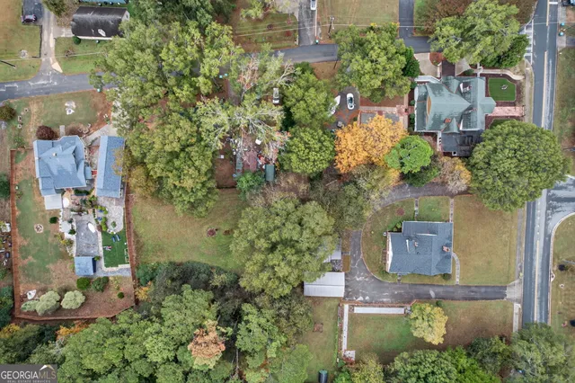 an aerial view of a house with a yard and large trees