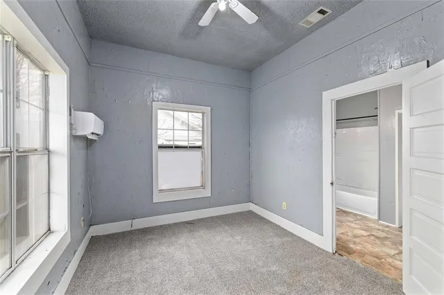 an empty room with windows and closet