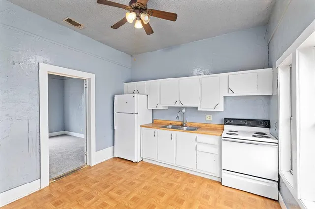 a kitchen with white cabinets and white appliances