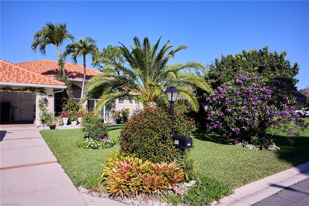 186 Muirfield Circle Naples, FL 34113 - Photo 33 of 36 a front view of a house with a garden