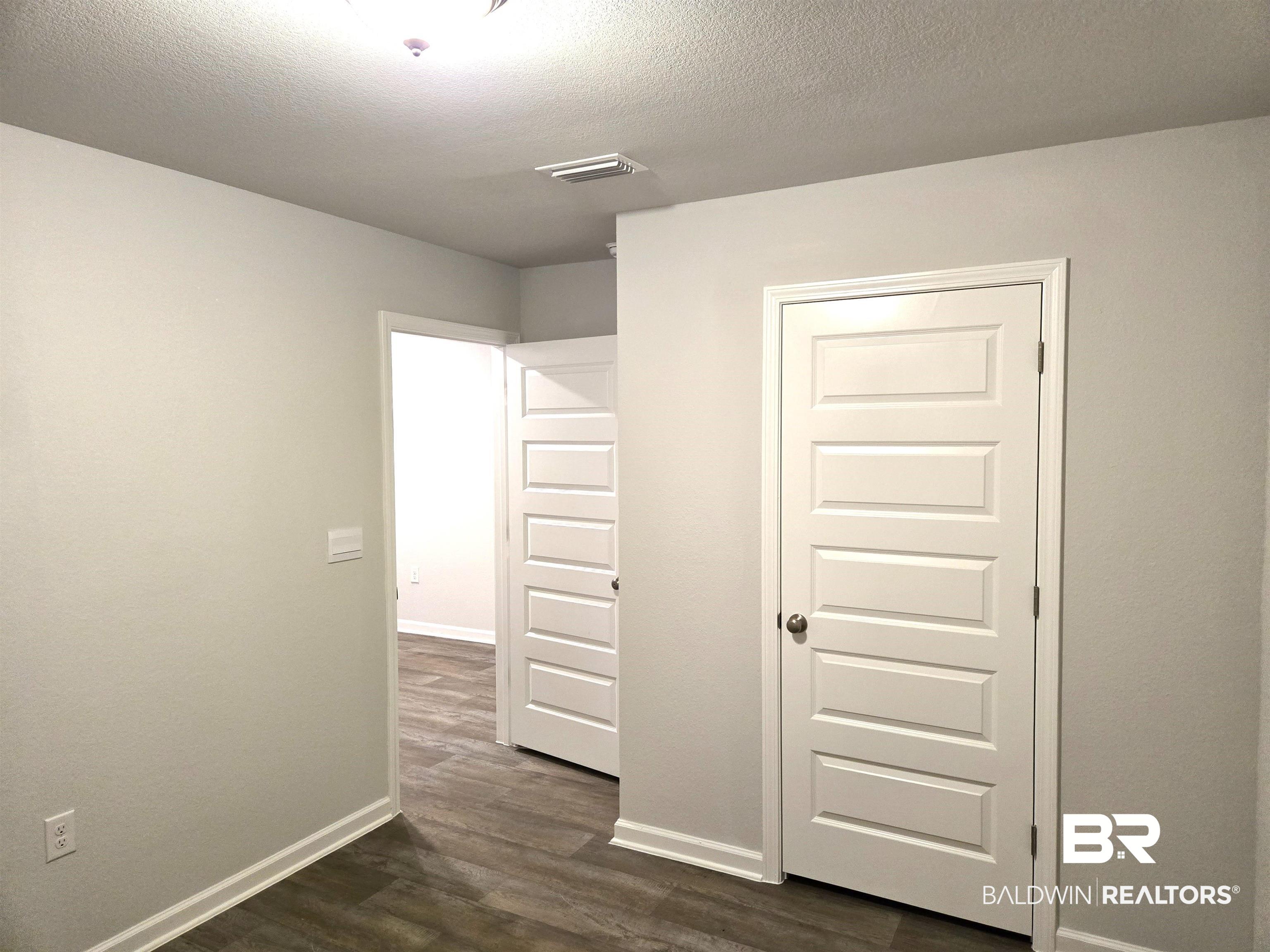 24227 Veranda Circle Elberta, AL 36530 - Photo 12 of 36 Unfurnished bedroom with a textured ceiling, dark hardwood / wood-style floors, and a closet