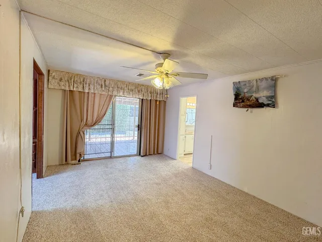 an empty room with closet and a chandelier fan