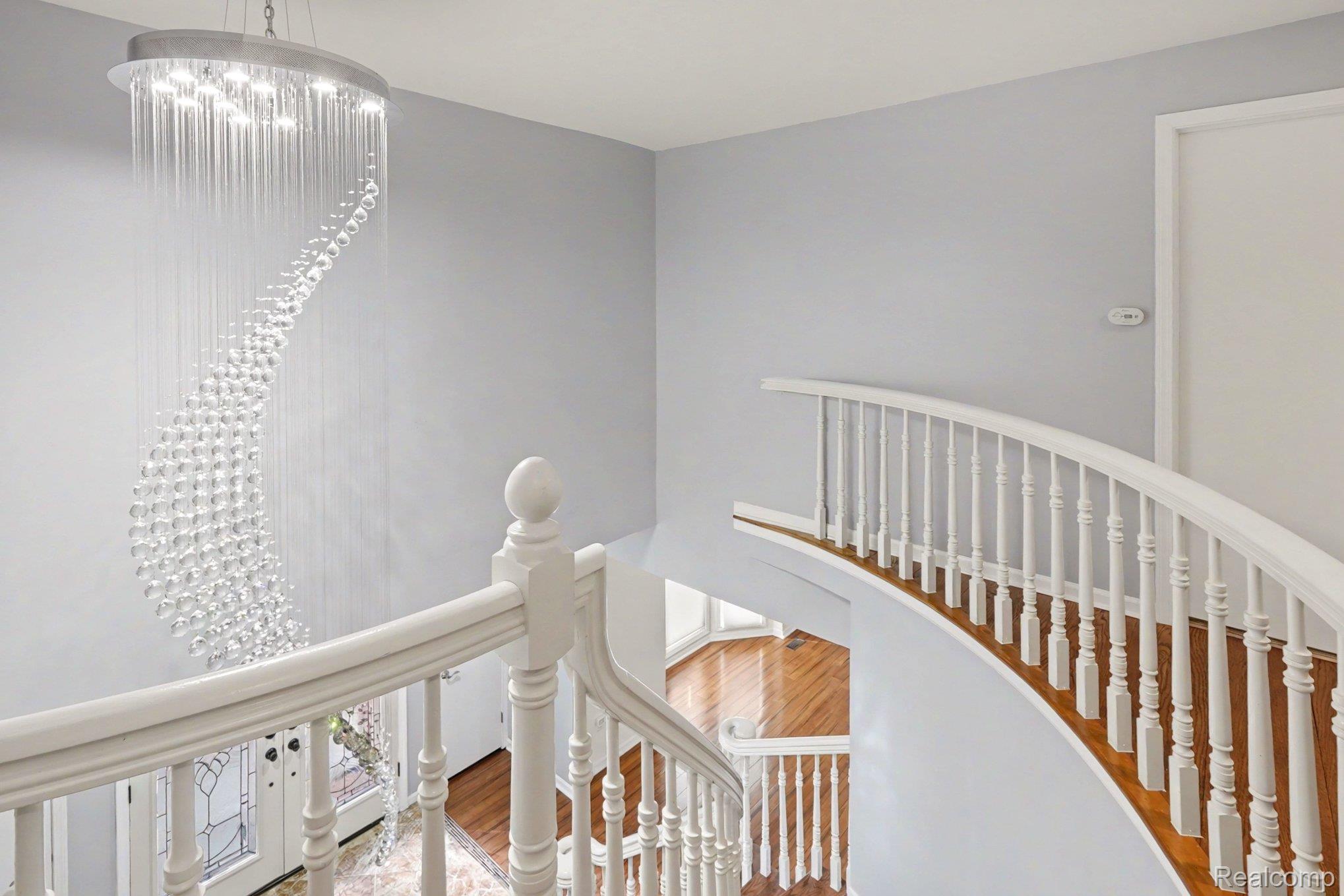 1941 Mapleridge Road Rochester, MI 48309 - Photo 22 of 55 Staircase featuring wood finished floors and a chandelier