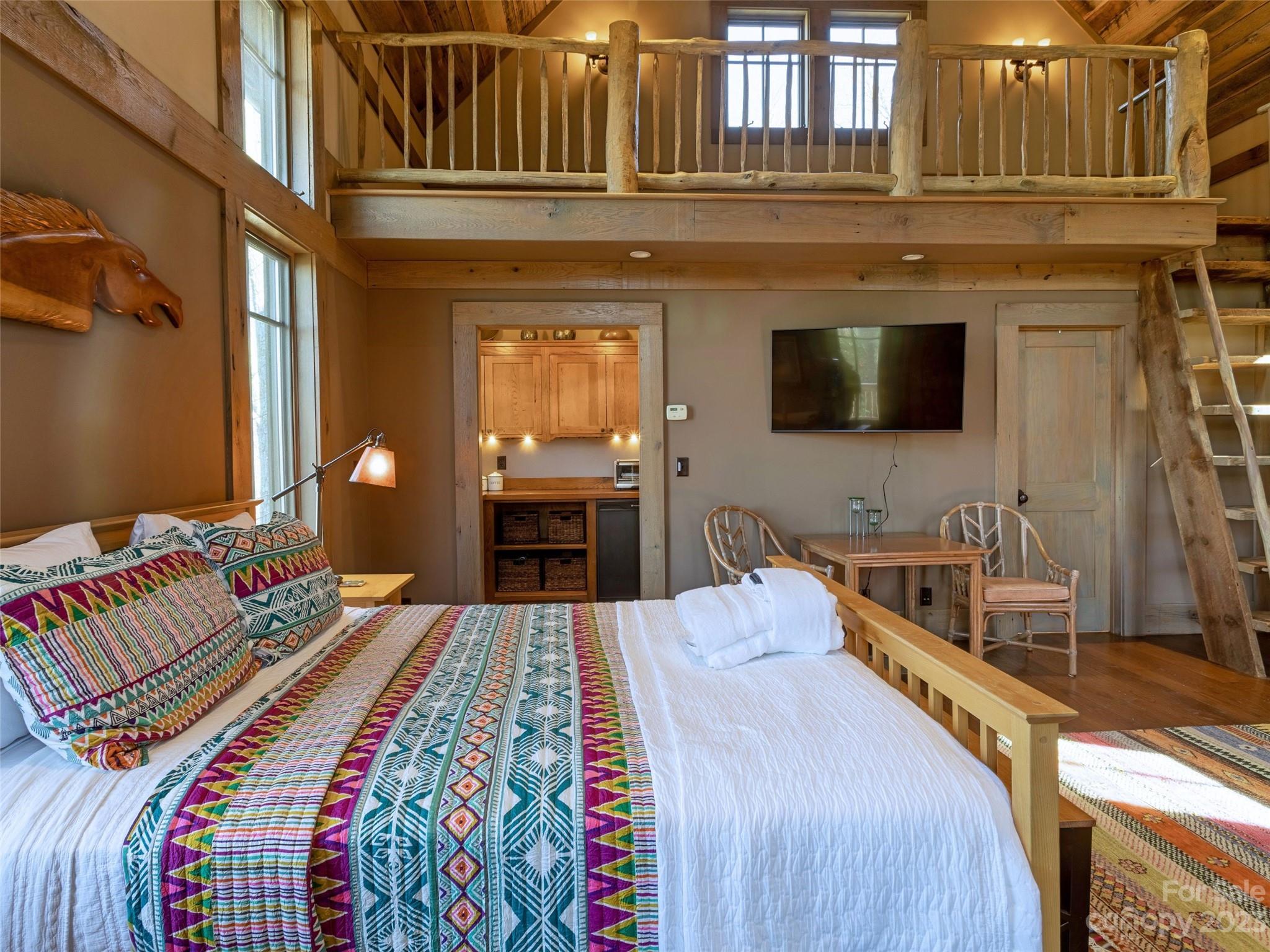 100 Boar Ridge Road Sylva, NC 28779 - Photo 41 of 48 a bedroom with a bed and a flat tv screen on dresser