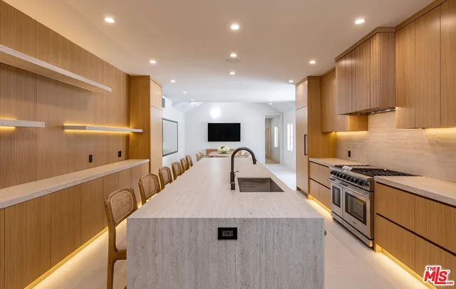a kitchen with a sink a counter top space and stainless steel appliances