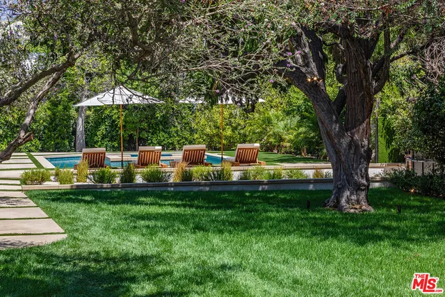 a view of a house with a swimming pool and sitting area