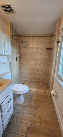 a bathroom with a toilet and a shower