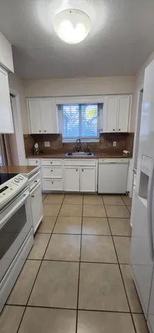 a kitchen with a stove a sink and cabinets