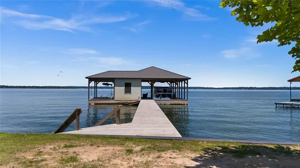 a view of a swimming pool with lawn chairs wooden floor and lake view