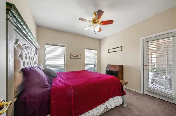 a spacious bedroom with a bed and a ceiling fan