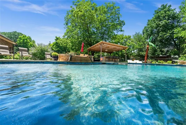 a view of a swimming pool with a patio and a yard